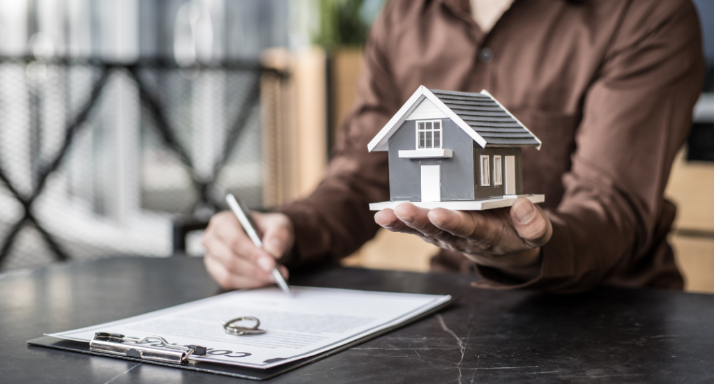 Agent holding a model house and signing a contract—answering the question, is there any all-in-one website for rental property?