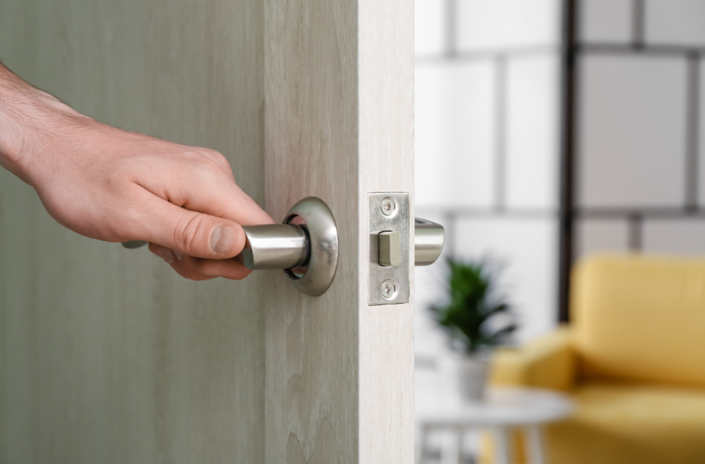 Hand opening a door with a sleek handle, showcasing a seamless virtual check-in experience for rental property.