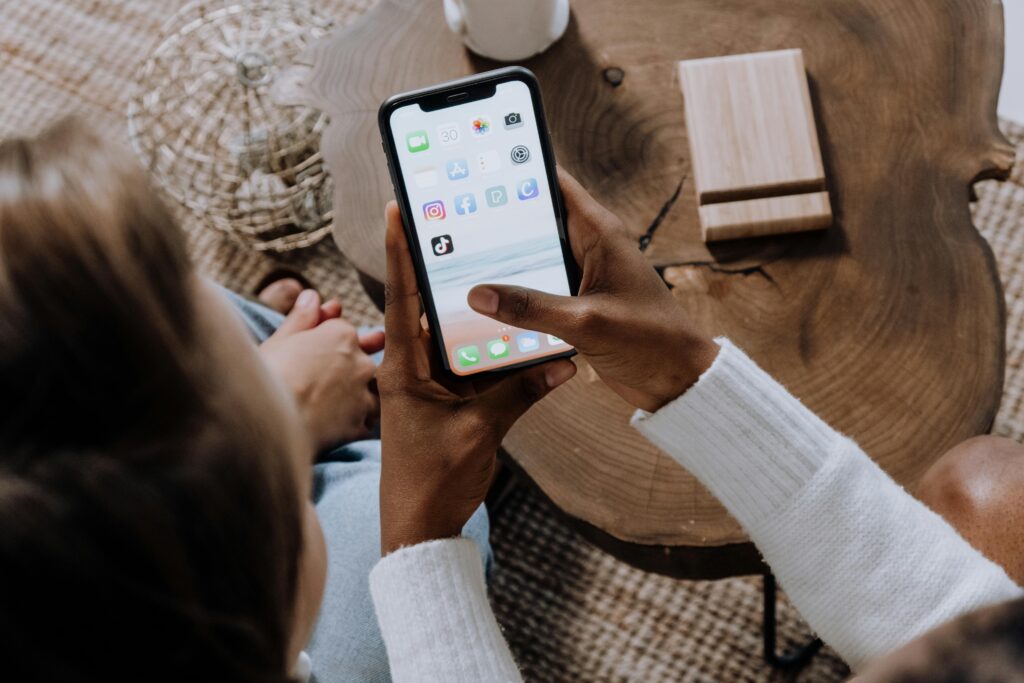 Person using a smartphone with multiple apps, symbolizing the accessibility and ease of the best vacation property management software.