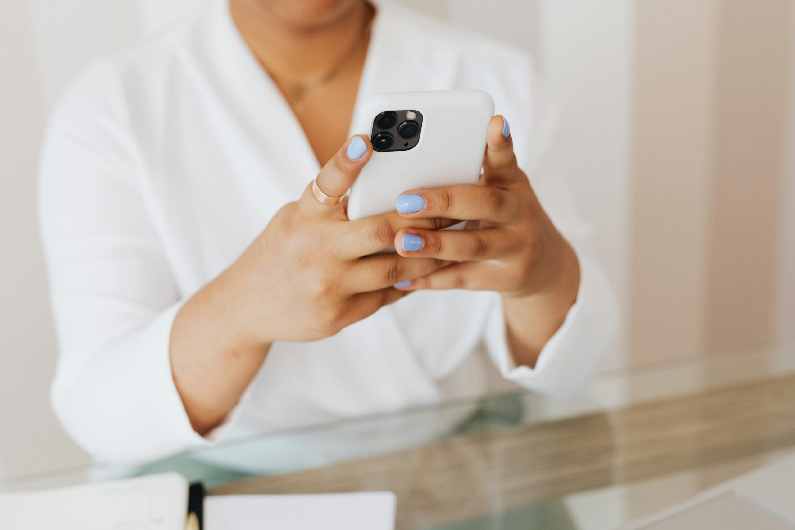 Close-up of hands holding a smartphone, illustrating efficient communication tools offered by the best vacation property management software.