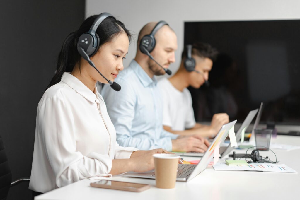 Customer support team using laptops, illustrating how excellent service can help earn more profit on short-term rental property.