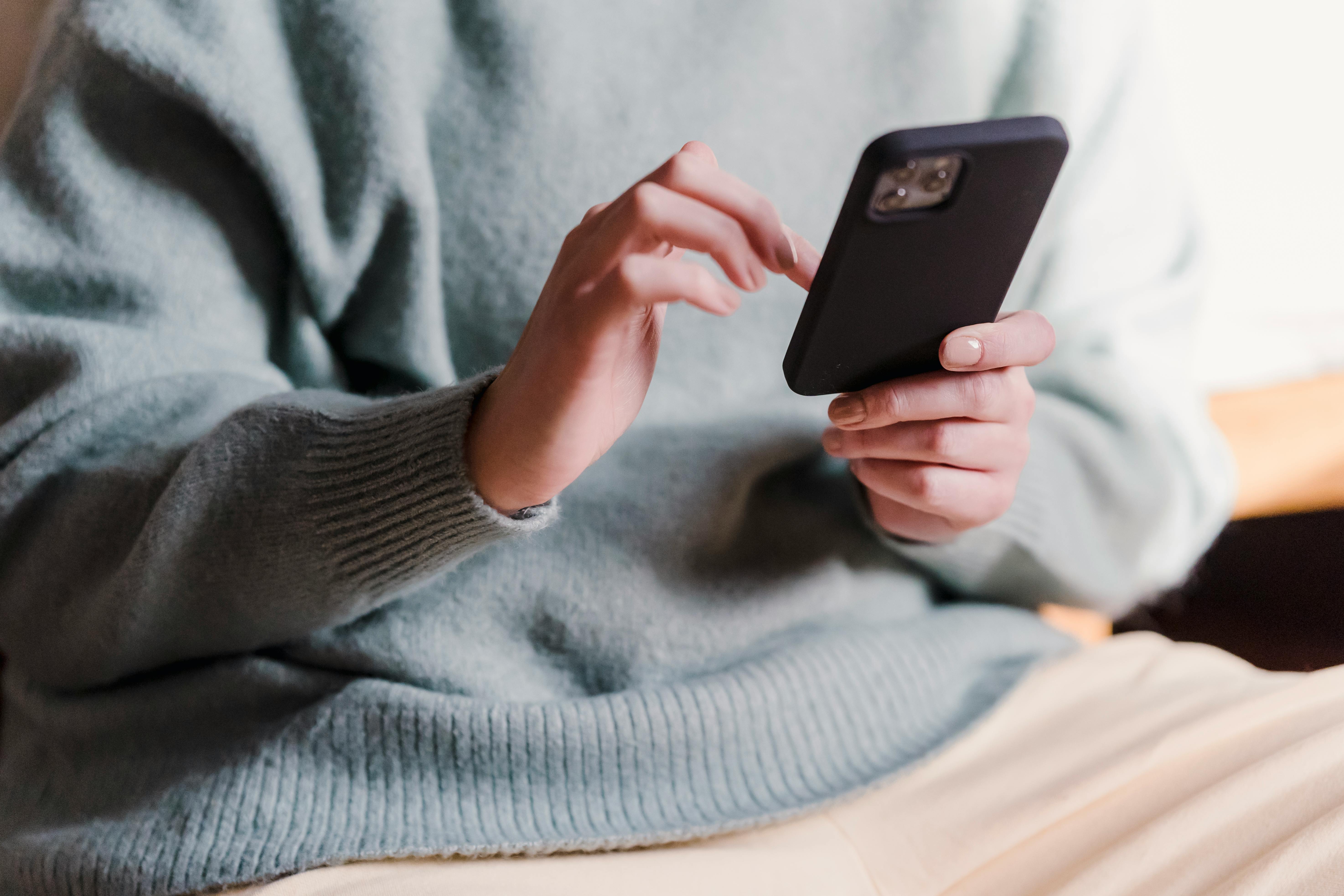 Person using a smartphone to update and manage an Airbnb housing list with ease.