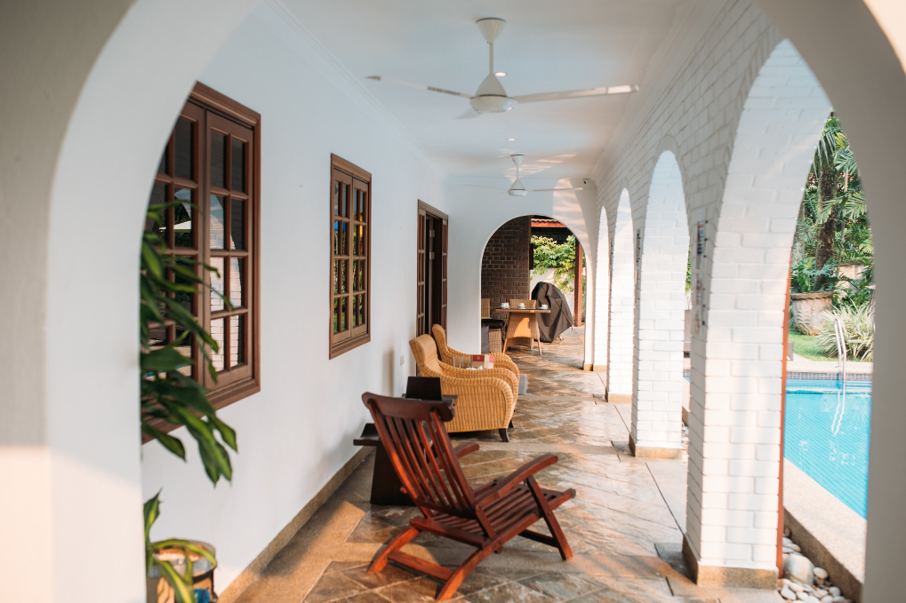 Bright and inviting outdoor corridor with poolside seating, showcasing high-quality STR photography for vacation rental marketing.